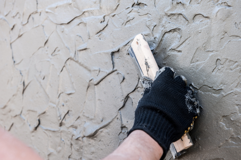 K-Boys Construction technician applies smooth stucco to a home exterior in Stuart, Florida.