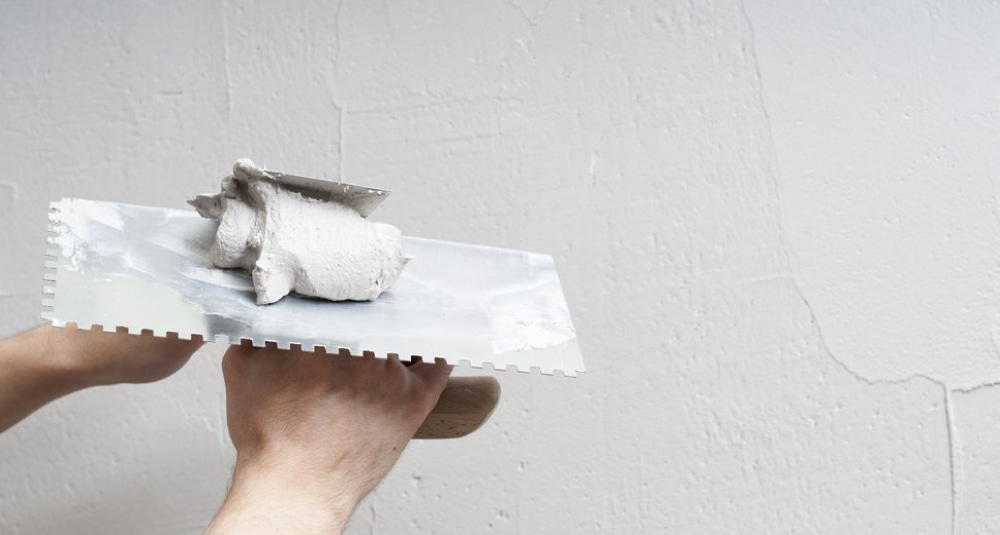 K-Boys Construction technician applies smooth stucco to a Wellington, Florida home exterior.