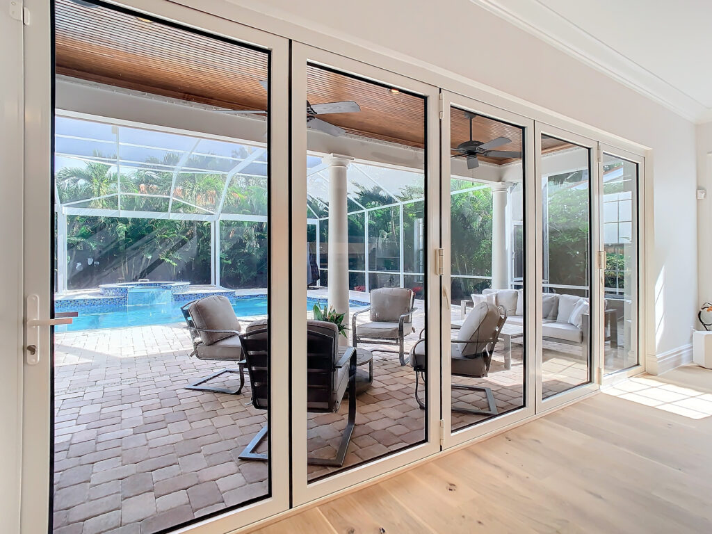 Technician installing hurricane-rated impact window and door on a home in Indiantown Florida