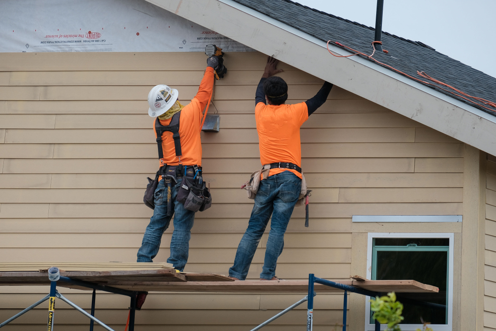 Siding team installing fiber cement panels on a Hobe Sound Florida home